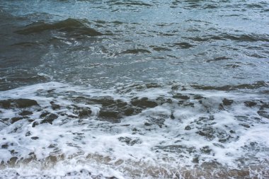 Deniz köpüğünde dalgalar kumsala vuruyor.
