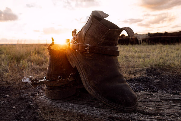 Pair of old drovers or cowboys boots taken off at the end of the day at sunset in outback Queensland, Australia.
