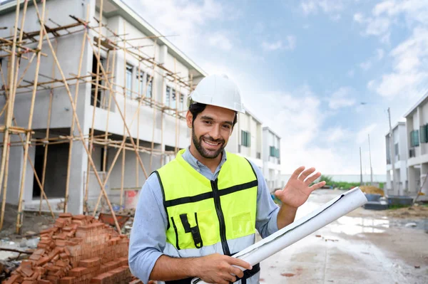 Young Constructor Engineer Man Smiling Holding Blueprint While Talking Building — Zdjęcie stockowe