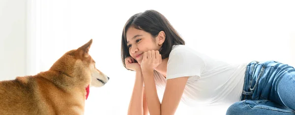 Banner cover design. Jocund young Asian woman lying on floor playing with Shiba Inu, Japanese dog. Cheerful and nice couple with people and pet. Pet Lover concept