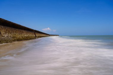 Deniz suyu dalgaları taşlardan oluşan dalgalara çarpıyor.