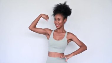 Young African American personal trainer explaining aerobics workout isolated gray background