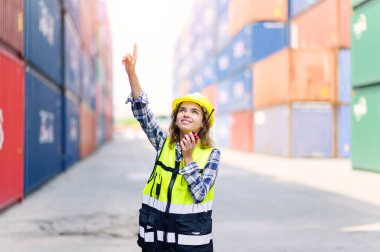 container operators women wearing helmets and safety vests control via walkie-talkie workers in container yards. Cargo Ship Import Export Factory Logistic.
