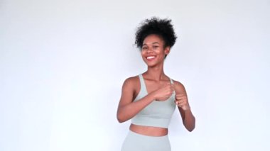 Young African American personal trainer explaining aerobics workout isolated gray background