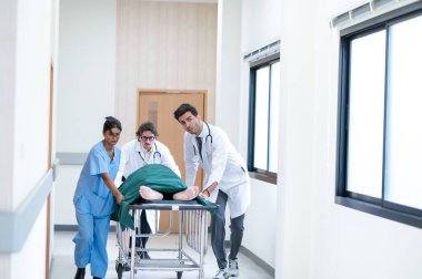 Doktorlar, hemşireler ve sağlık görevlileri, ağır yaralı hastalarla sedye yatağını ameliyathaneye doğru itiyorlar. Profesyonel Çalışanlar Hayat Kurtarıyor. Sağlık Hizmetleri Konsepti