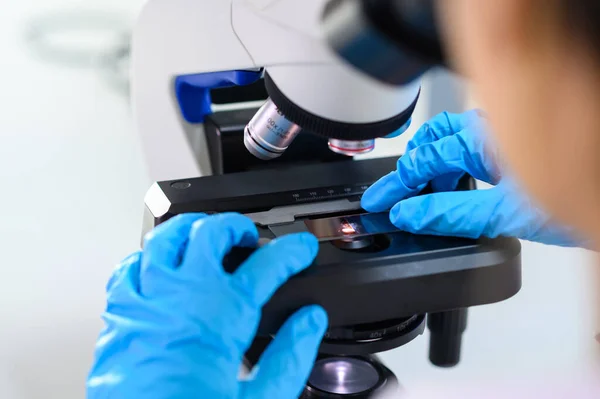 这位科学家交上蓝色手套 在显微镜下观察样品 医学科学实验室 — 图库照片
