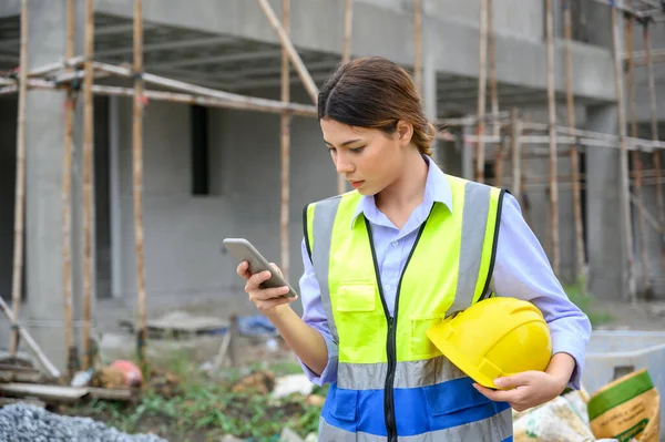 Jonge Ingenieur Vrouw Vest Houd Gele Helm Staande Gebruik Smartphone — Stockfoto