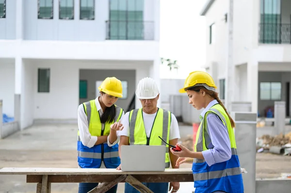 Group Contractors Engineers Formats Safety Vests Helmets Working Laptop Standing — Zdjęcie stockowe