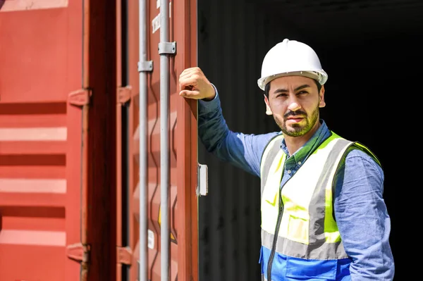 container logistic operators workers wearing yellow helmets and reflection shirts and open containers for inspection and check the condition of containers at warehouse container yard. logistics business import export industry