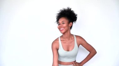Young African American personal trainer explaining aerobics workout isolated gray background