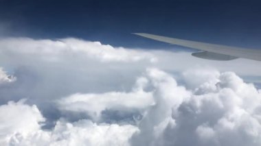 Uçak uçuşu. Uçağın kanadı bulutların üzerinde uçuyor. Gökyüzüne uçağın penceresinden bak.