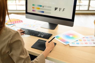 Asyalı kadın sanatçı grafik tablete bir şeyler çiziyor. Ofiste çalışan grafik tasarımcısı