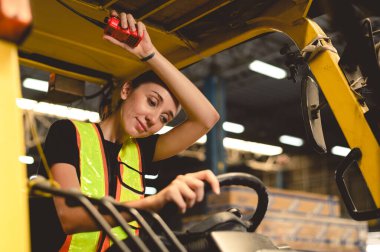 İşinden bezmiş çalışanlar. Kadın forklift sürücüsü depoda çalışmaktan yorgun düşmüş.