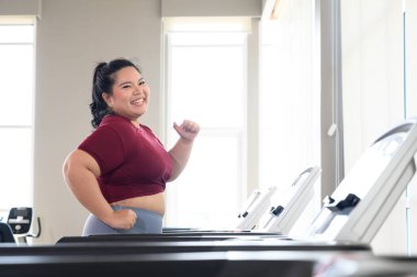 Spor giyimli Asyalı şişman kadınlar spor salonunda koşu bandında koşuyorlar. Kilo verme egzersizi, sağlıklı yaşam tarzı konsepti