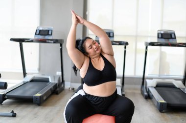 Artı fitbolda beden eğitimi alan bir kadın. Kilolu kadınlar spor salonunda egzersiz yaparlar. Kilo verme egzersizi, sağlıklı yaşam tarzı konsepti