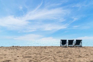 Kumsalda dinlenme zamanı. Güneşli günlerde mavi gökyüzü olan Tayland sahilindeki gezginler için hazırlanmış plaj şezlongları. Yaz tatili ve tatil