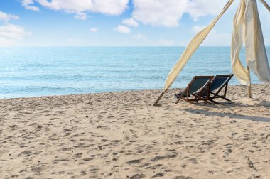 Kumsalda dinlenme zamanı. Güneşli günlerde mavi gökyüzü olan Tayland sahilindeki gezginler için hazırlanmış plaj şezlongları. Yaz tatili ve tatil