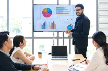İş Adamı Konferans Odasında İş Ekibine Sunum Raporu Veriyor, TV 'de Dijital Bilgi Grafikleri ve Şirket Büyümesi Hakkında Turta Grafikleri Gösteriyor
