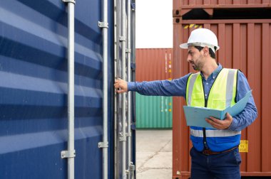 Foreman ya da Mühendis, konteynır kutusunun envanter detaylarını kontrol etmek ya da kontrol etmek için beyaz kask ve yansıtma gömleği giyer. Ticari lojistik sektörünün ithalat ve ihracatında kargo taşımacılığı yapan konteyner