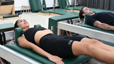 Erkekler ve kadınlar fiziksel sağlığı korumak için kaslarını güçlendirirler. Spor salonundaki pilates derslerini seven bir çift.