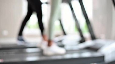Spor salonunda koşu bandı. Koşu bandında koşan bacakların yan görüntüsü. Kardiyo çalışması