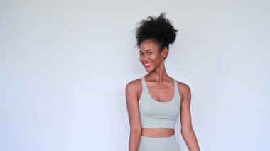Young African American personal trainer explaining aerobics workout isolated gray background