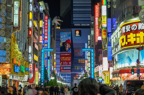 TOKYO, JAPON - 8 Nisan 2025. Gece vakti Shinjuku 'daki Toho sinemasının tepesindeki Godzilla baş heykelinin gece görüşü. Geceleri mahalleyi aydınlatan Neon levhalarla.