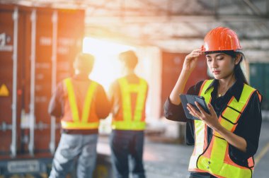 Asyalı kadın depo yöneticileri, iş yerindeki depoda stok sipariş detaylarını ve malzeme malzemelerini dijital tabletlerle kontrol ediyorlar. sanayi lojistik ihracat ithalat dağıtım kavramı