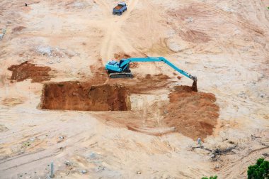 İnşaat alanı. Büyük çapa manzaralı, ağır kamyon çalışıyor.