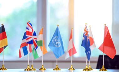 BM bayrağı, üye ülkelerinin bayraklarıyla birlikte masada.