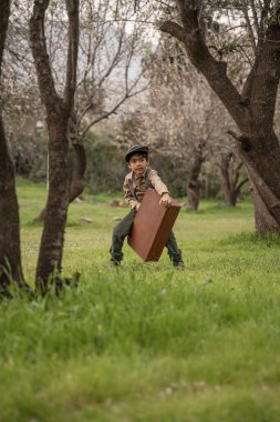 Parkta bavullu bir çocuk.