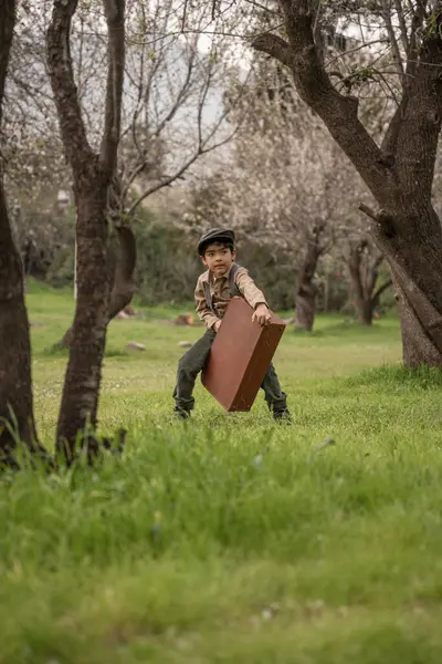 Parkta bavullu bir çocuk.
