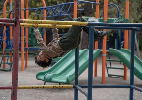 Çocuk parkta oyun malzemeleriyle oynuyor.