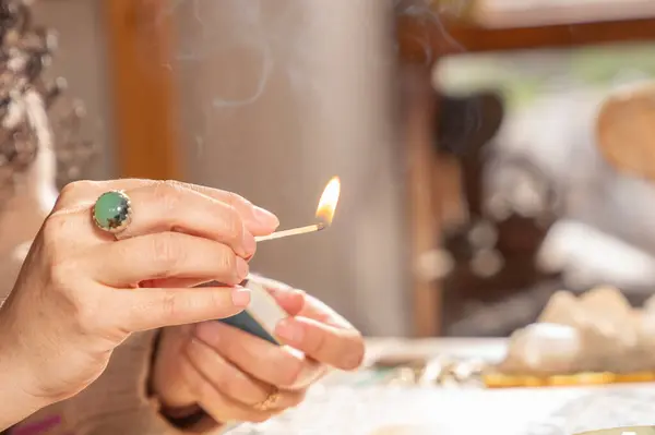Holistik terapist tütsü çubuğu yakıyor.