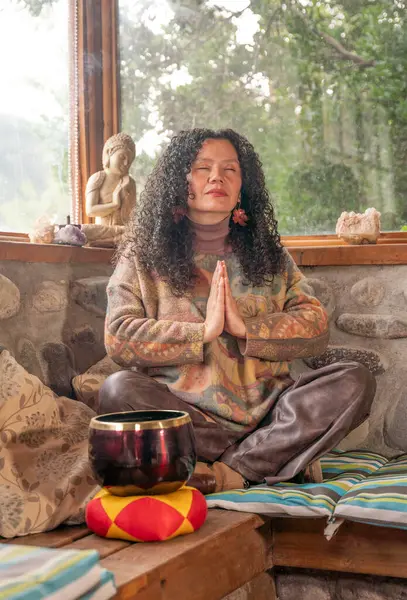 Kadın içeride Buda heykeliyle meditasyon yapıyor.