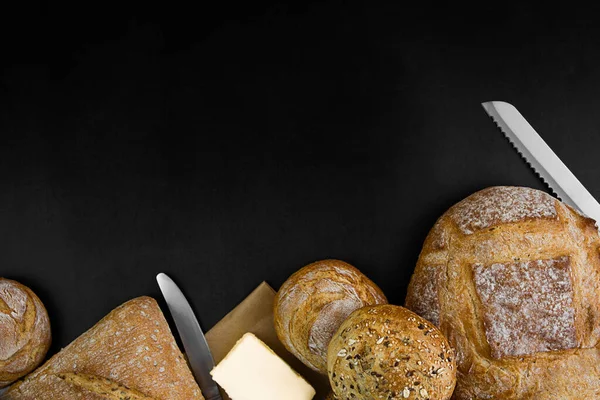 Freshly baked bread on a black background. Copy space. Bakery concept.