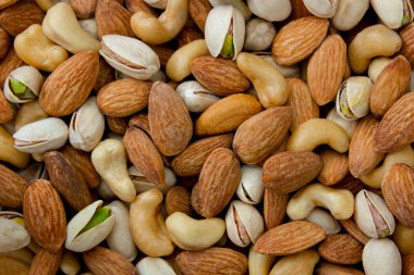 Mixed nut background. Cashews, almonds and pistachios. Concept of healthy eating. clipart