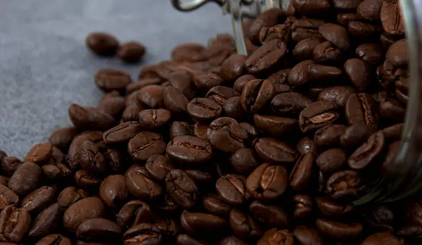 Geröstete Kaffeebohnen Auf Dunklem Steinhintergrund Verstreut — Stockfoto