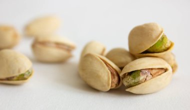 Roasted, salted pistachios on a white background. Soft focus. Concept of healthy eating. clipart