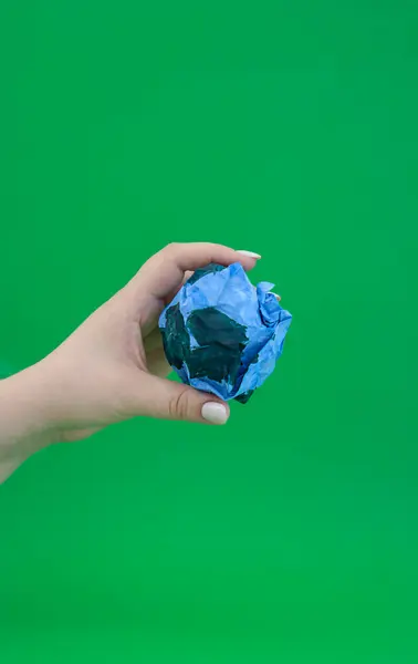 stock image A persons hand holding paper for Earth Day.