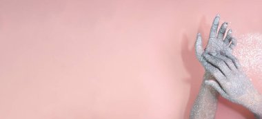 Parlak gümüş renkli parlayan paltolar dokundukları zaman ellerini pembe bir duvara değdirirler, karşıtlık sergilerler.