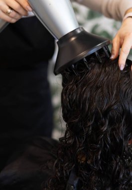 Kuaför salonunda saç kurutma makinesi olan profesyonel bir kuaför.