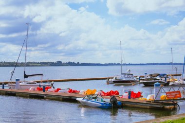 Göl kenarındaki sakin bir rıhtımda birkaç tekne demirlemiş..