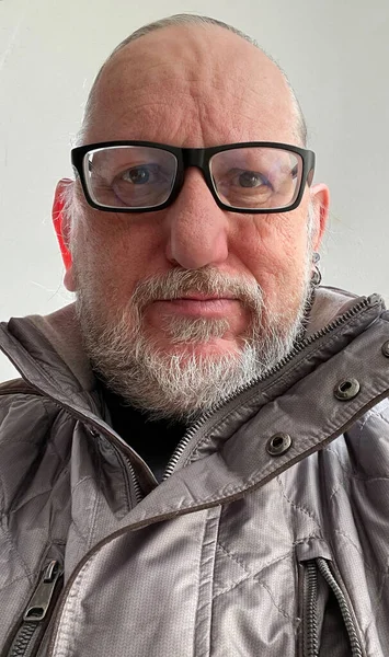 Starszy Mężczyzna Wyglądający Poważnie Przed Kamerą Imponujące Okulary Czarną Obręczą — Zdjęcie stockowe