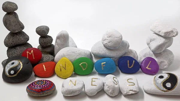 Mindfulness painted on colored stones with two yin yang stones. Rock painting