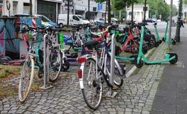 Duesseldorf, Almanya - 2 Ağustos 2023 Kiralık e-scooterlar motorlar arasında kaotik bir şekilde park halindedir. Bunlar Kademe, Hesap ve Voi 'den.. 