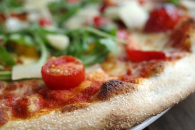 Domatesli lezzetli vejetaryen pizza, roka yaprağı ve parmesanlı peynirli vejetaryen pizza domates, roka yaprağı ve parmesan peyniri.