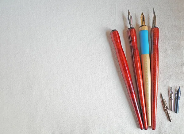 Dip pens with holders lying on handmade paper