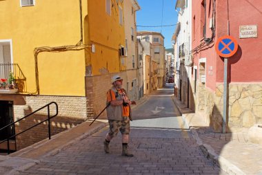Cesur bir Alman turist İspanya 'nın Castalla şehrinde renkli bir caddede yürüyor..