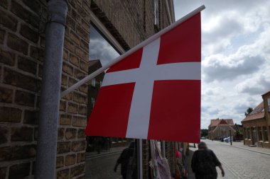 A small Danish flag hangs on the facade of a shop clipart